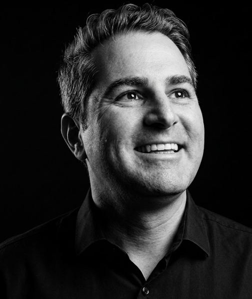 Black and white portrait of Renato Espeschit, smiling.